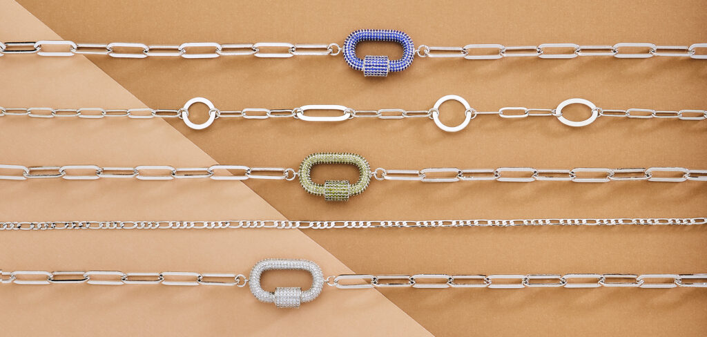 assorted silver bracelets on buff colored background with soft lighting
