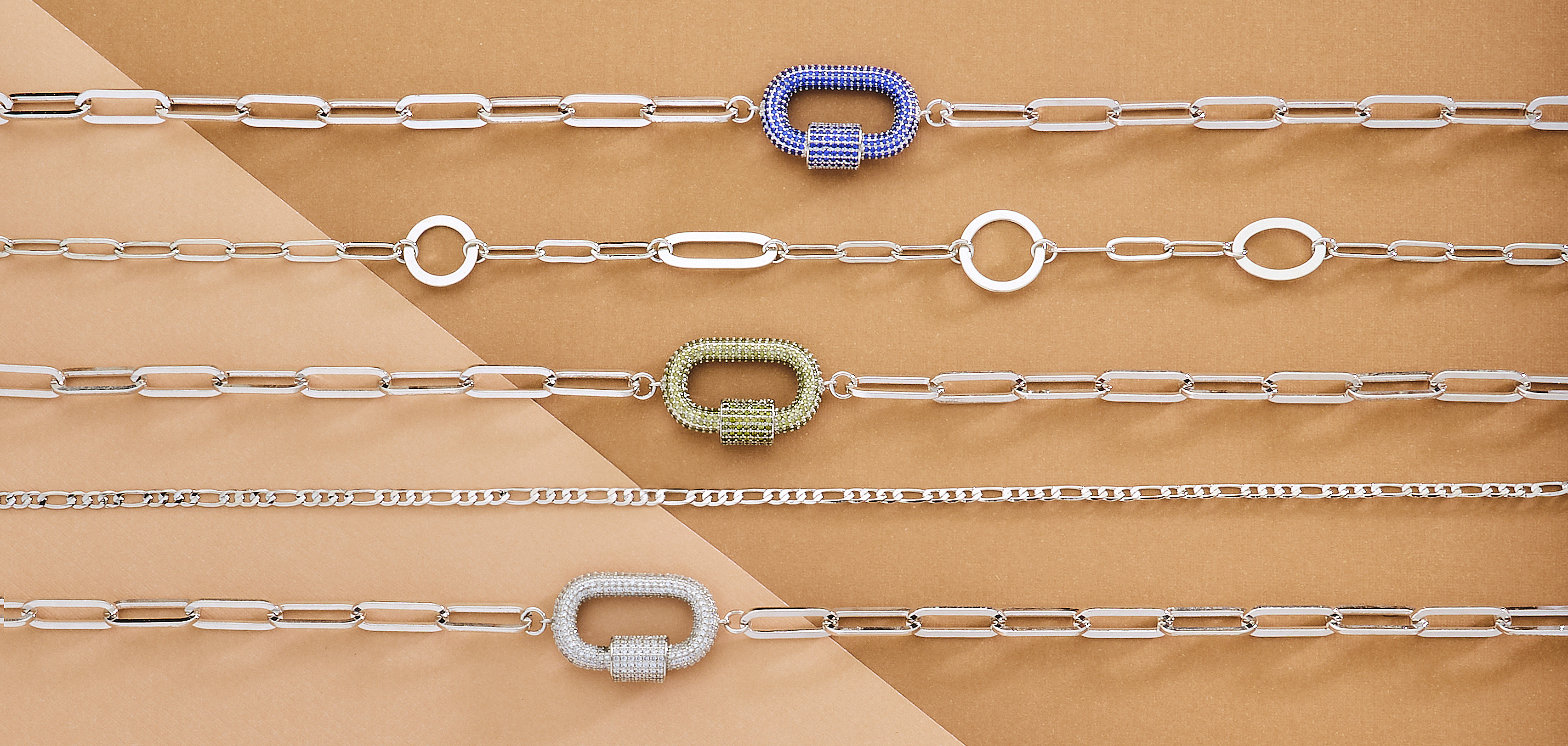 assorted silver bracelets on buff colored background with soft lighting