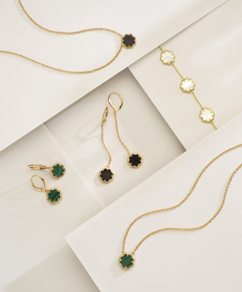 onyx, mother of pearl and malachite jewelry on neutral background