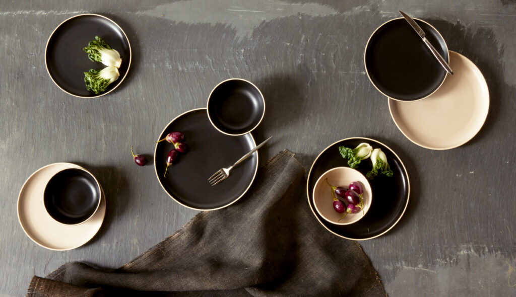 modern minimalistic dinnerware with earthy fresh vegetables on slate surface