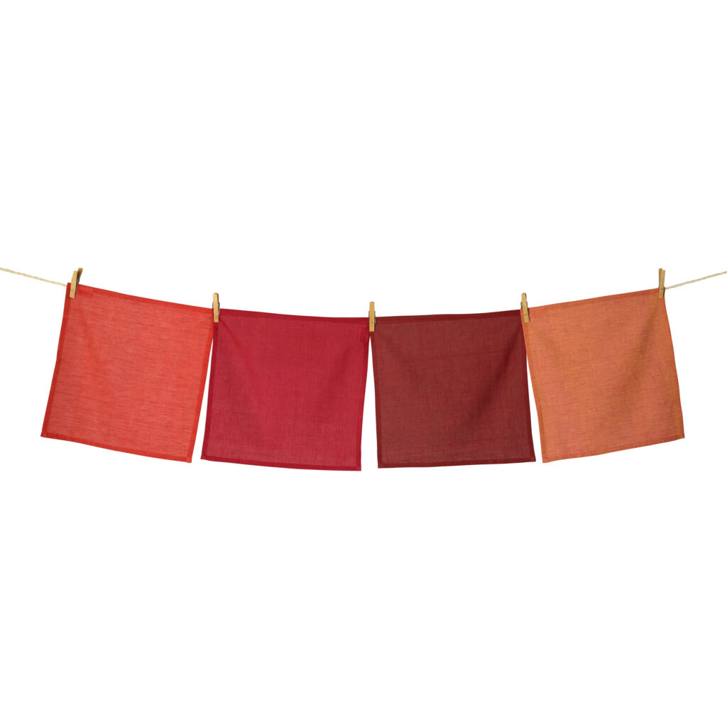 Sustainable Threads fair trade handwoven red and orange napkin set hanging on wash line on white background