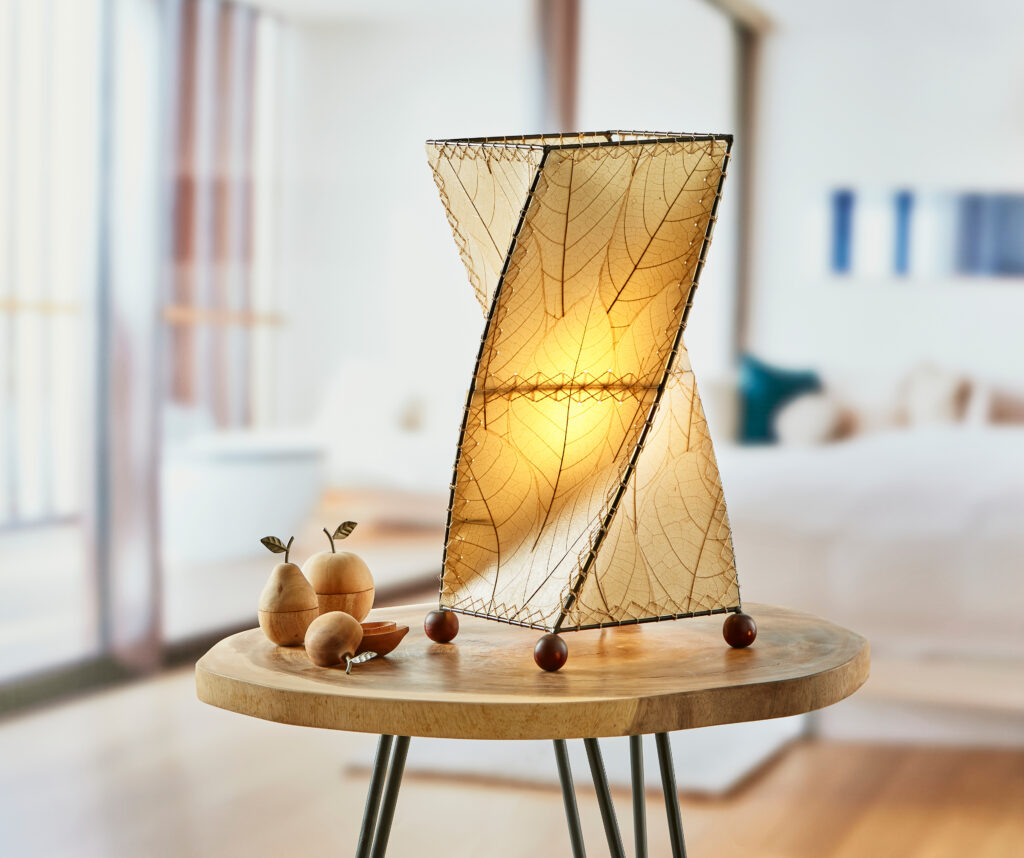 Twisted fair trade table lamp in warm neutral tone in bedroom setting