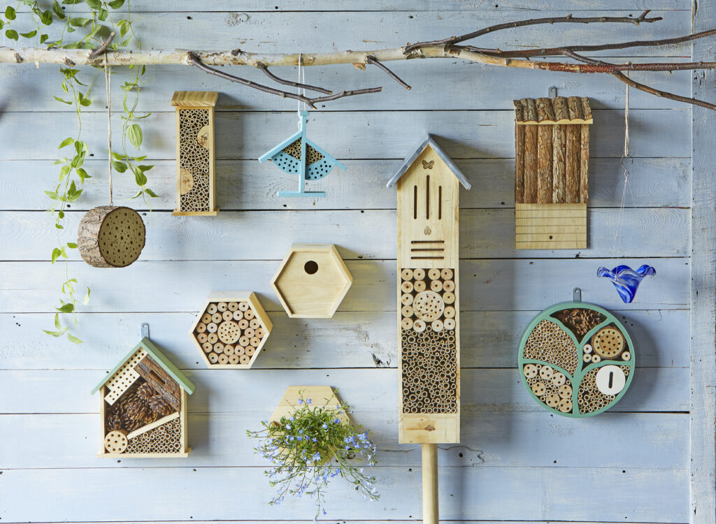 assortment of bamboo bee houses on a faded blue wall