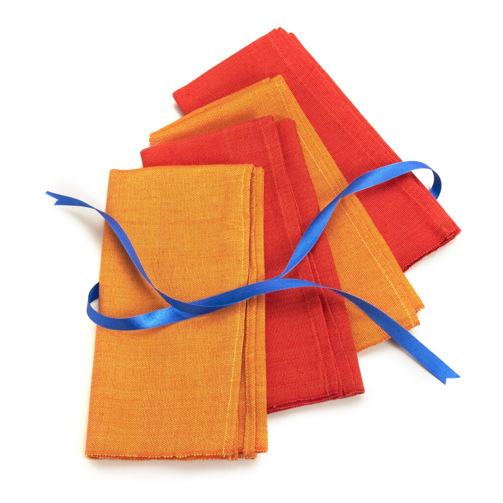 orange napkins tied with blue ribbon on white background