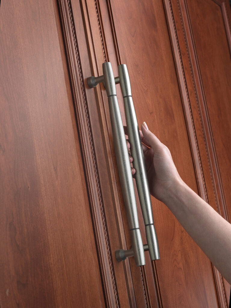 Amerock Appliance pulls with hand on mahogany cupboard