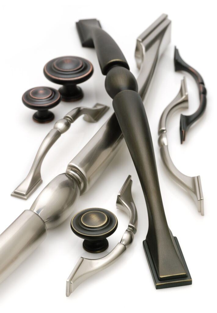 Amerock hardware in various finishes artfully arranged together with soft lighting on a white background