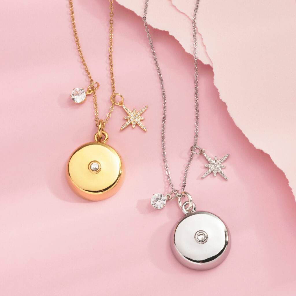 gold and silver pendants on pink background