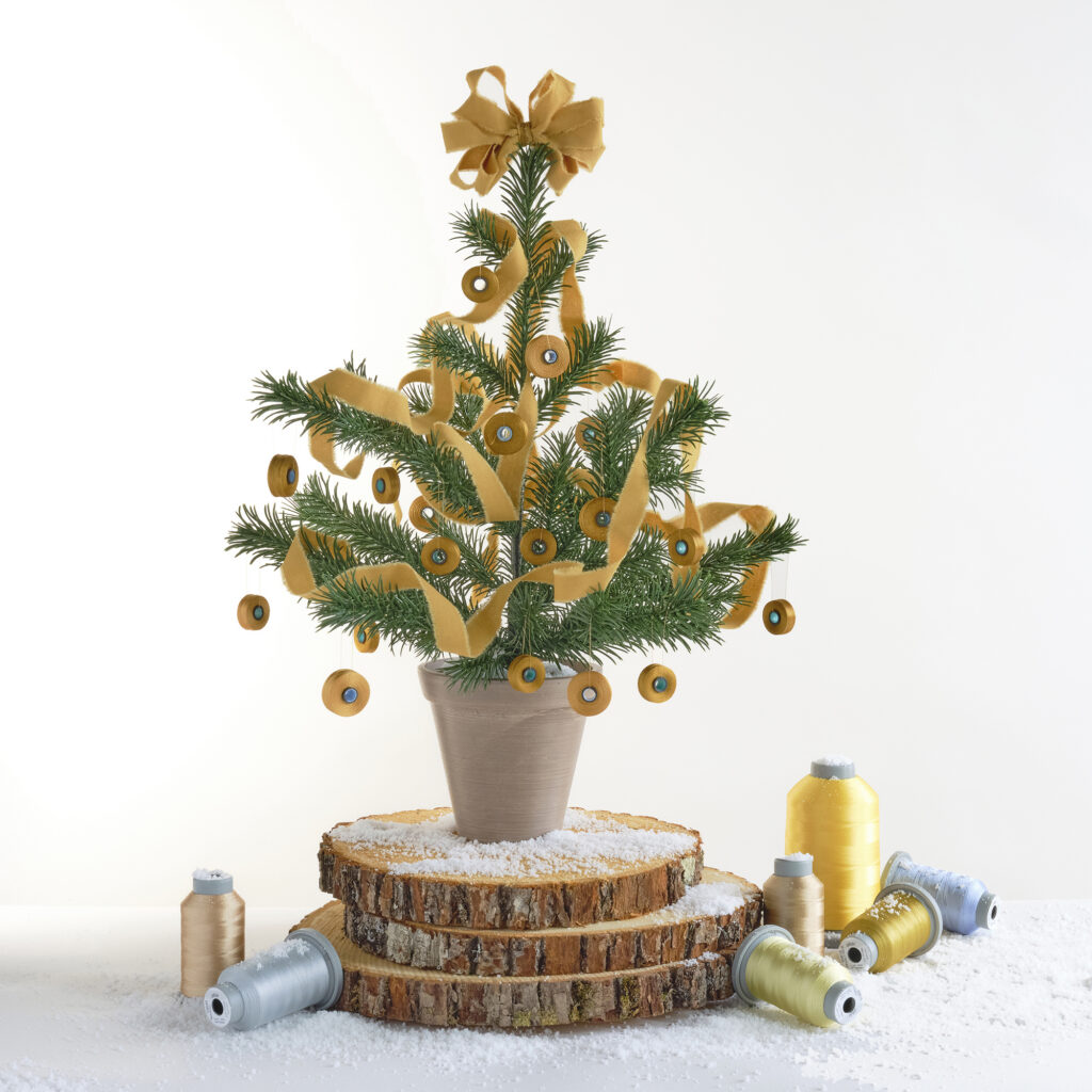 small faux Christmas tree decorated with gold bobbins and other threads
