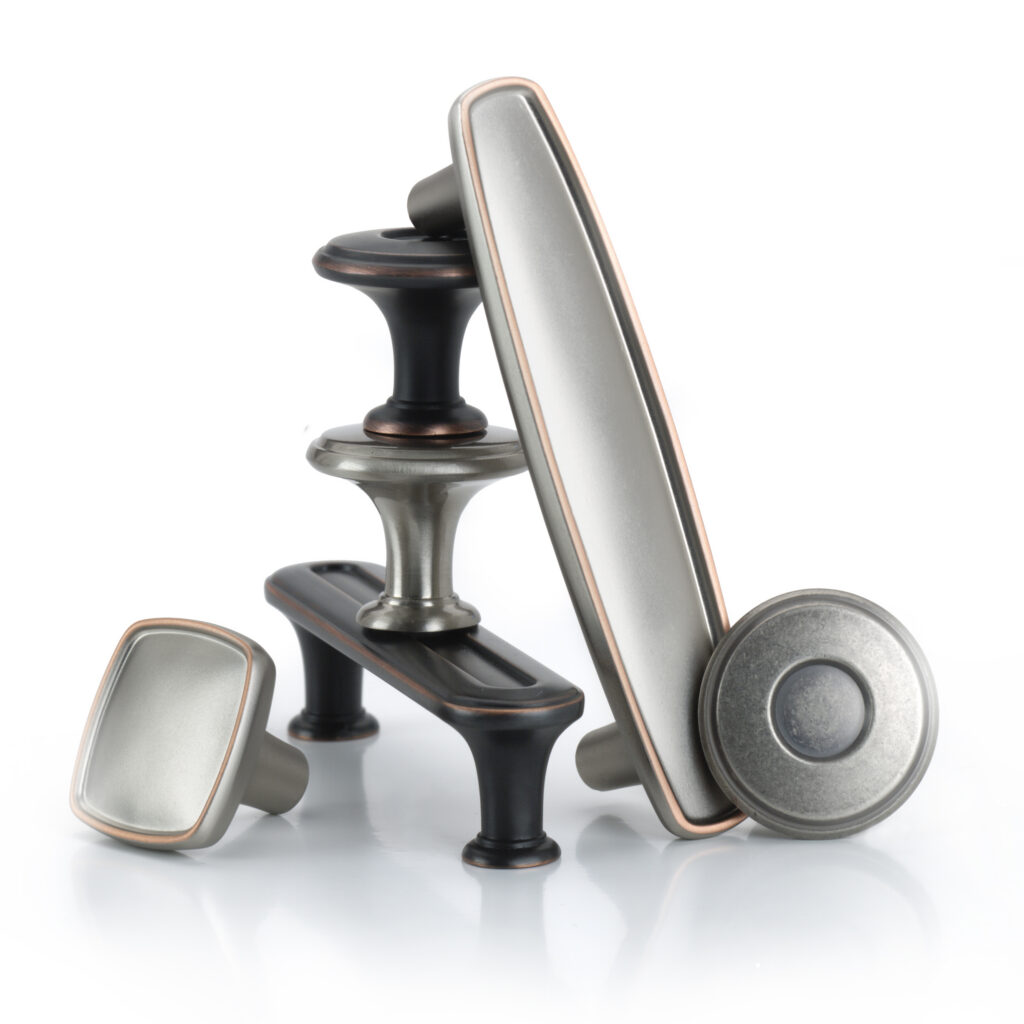 Amerock Coles oil rubbed bronze and satin nickel hardware arranged as sculpture on white background
