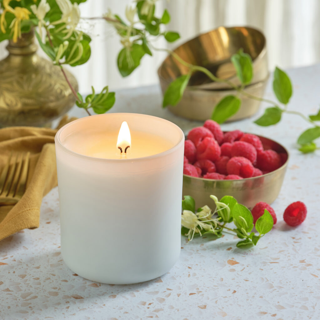 Cue Candle Company white candle with fresh raspberries