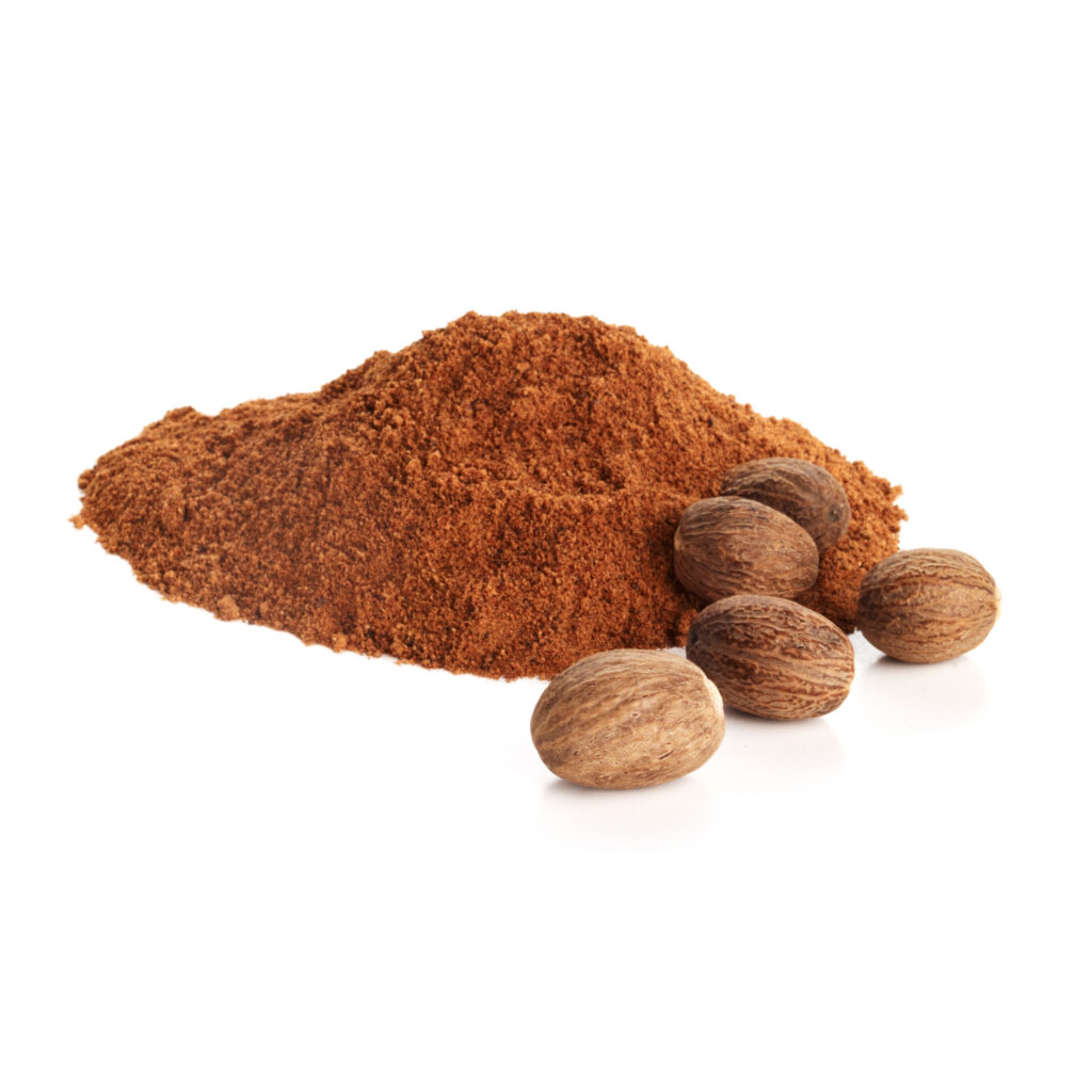 ground nutmeg with whole nuts on white background