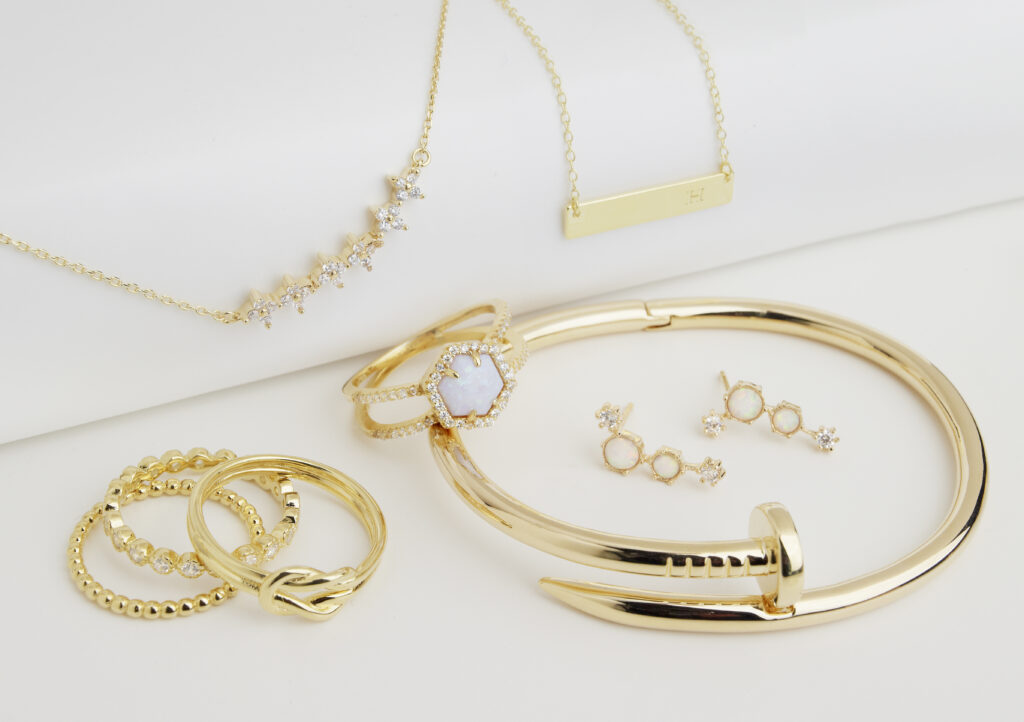 assorted opal gold and silver jewelry with dramatic shadows