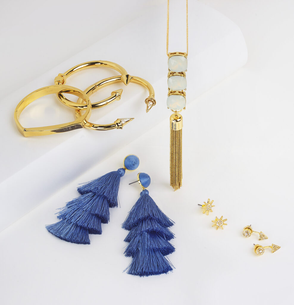 assorted jewelry on neutral colored background with soft lighting