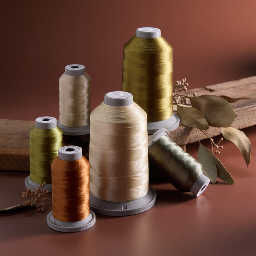 muted fall colored thread with dried leaves and wooden shelf