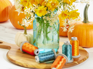 beautiful turquoise and orange thread in blue jar with pumpkins and wild flowers