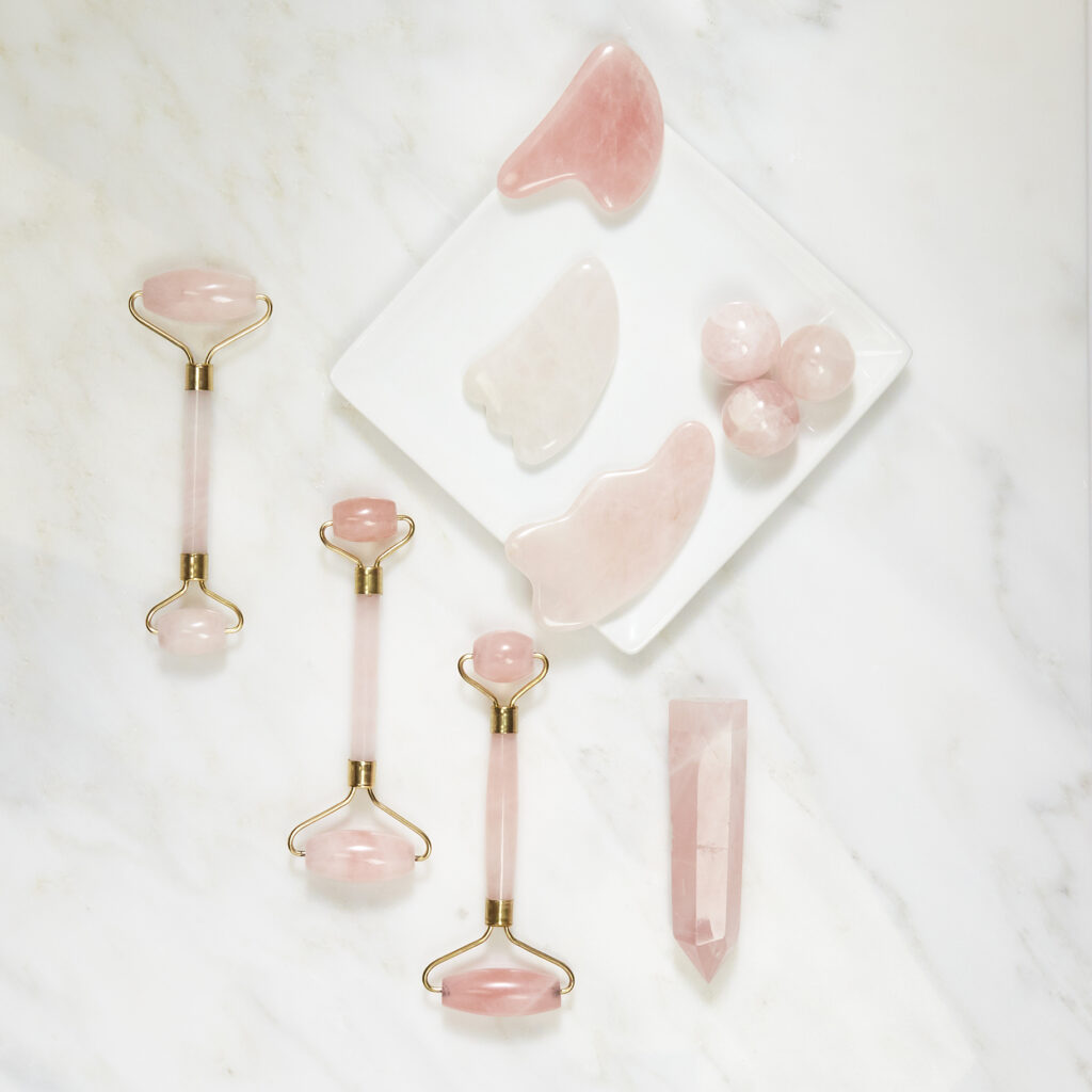 luxury beauty brand pink quartz rollers on white marble