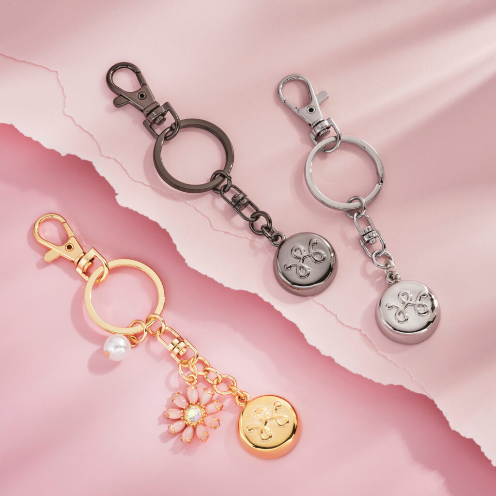 gold silver and pewter key chains on pink background with dramatic shadows