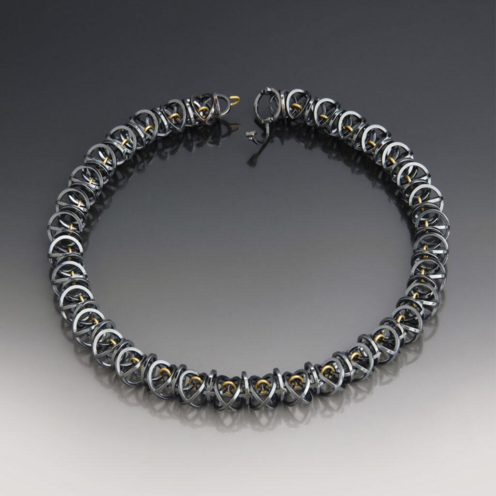 handcrafted necklace on on graduated background with reflection