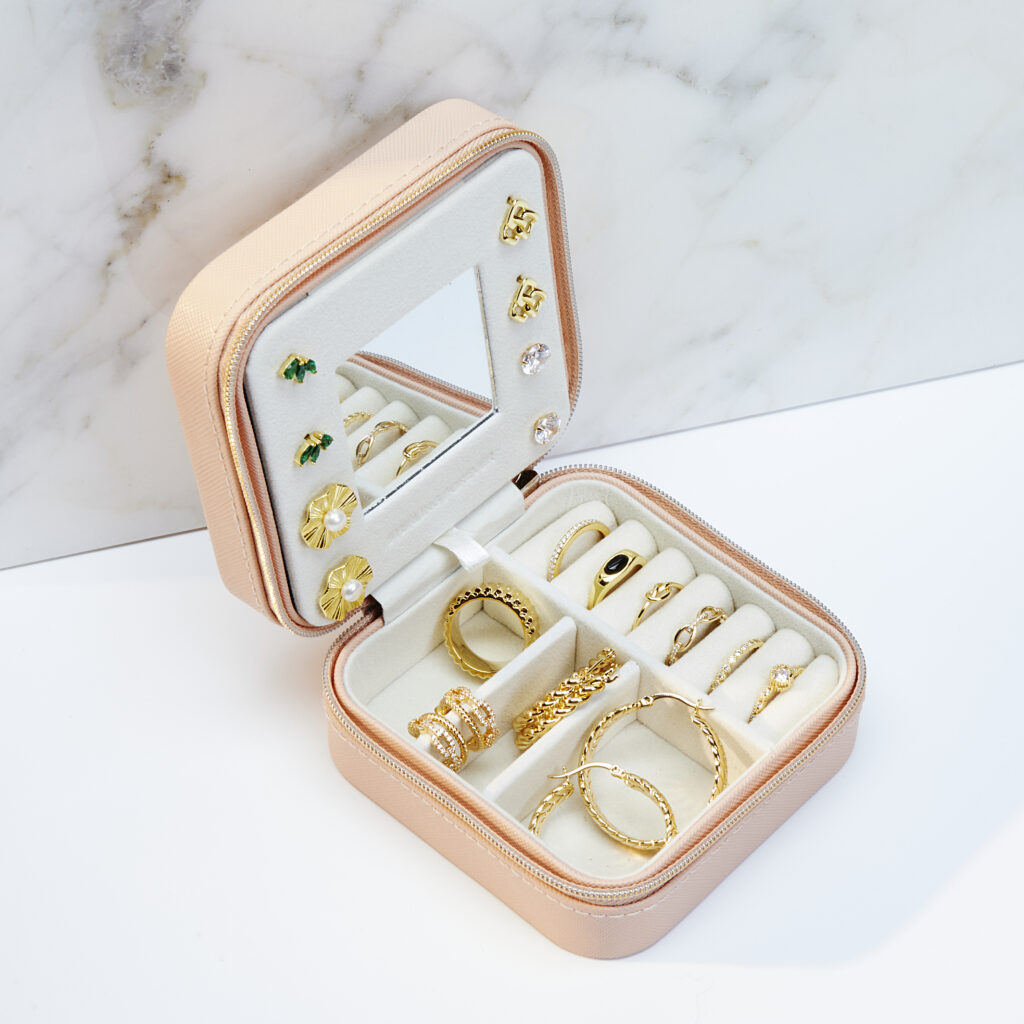 small travel jewelry case on marble and white background with shadows