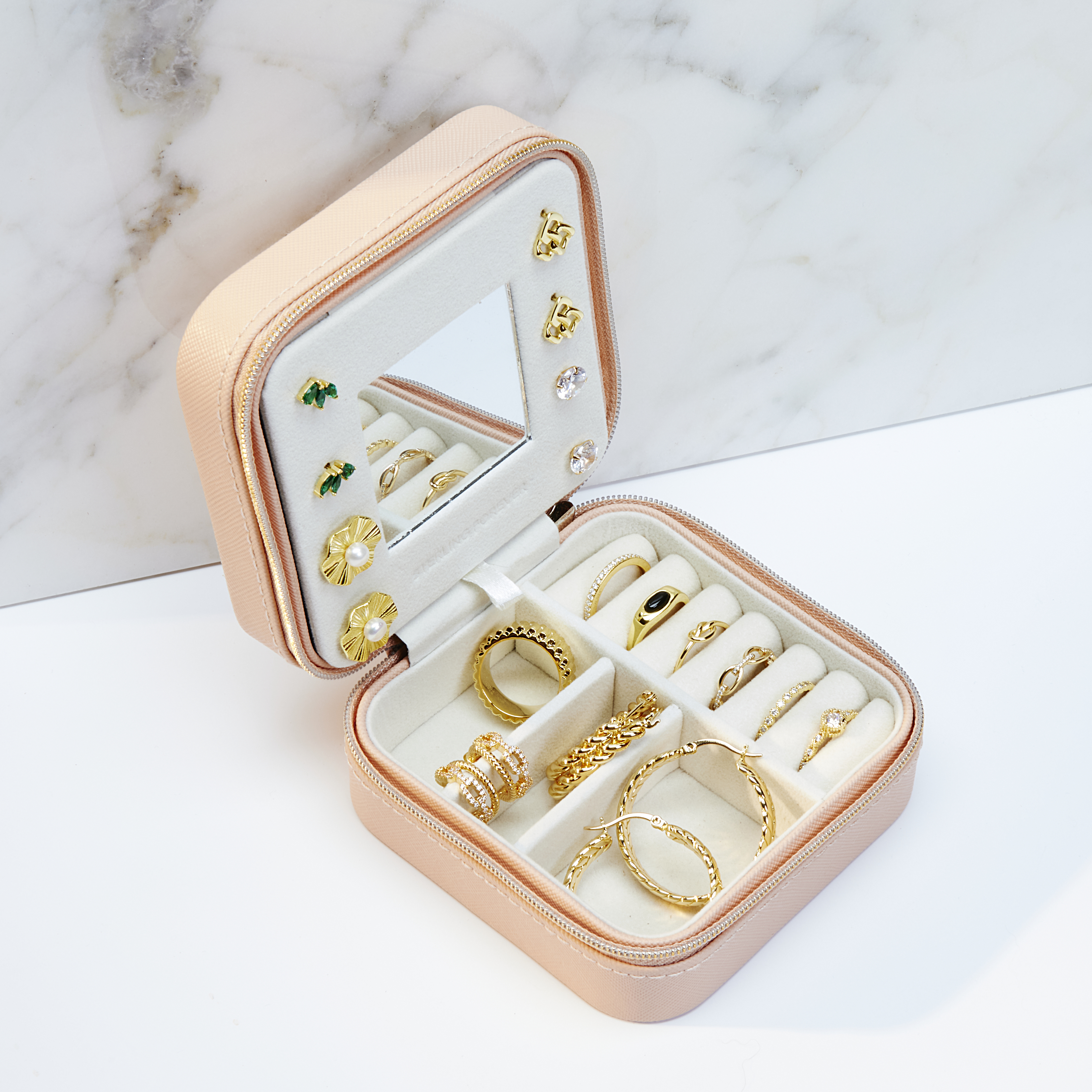 small travel jewelry case on marble and white background with shadows