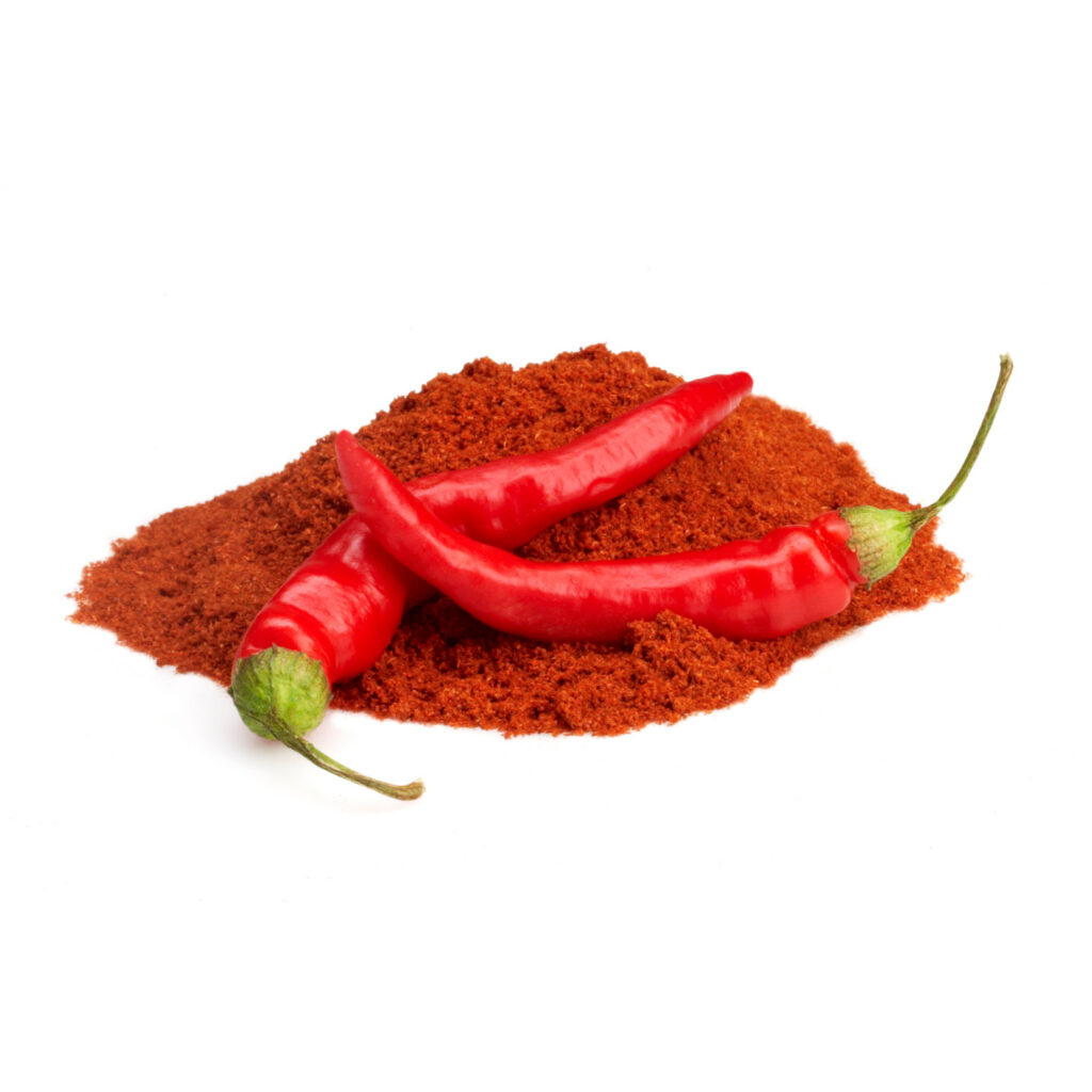 pile of ground red pepper with chilies on white background