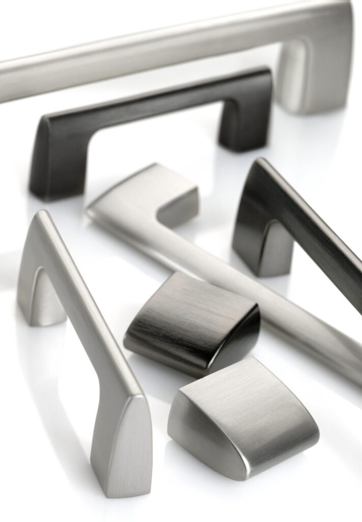 Amerock Riva hardware in various finishes artfully arranged together with soft lighting on a white background