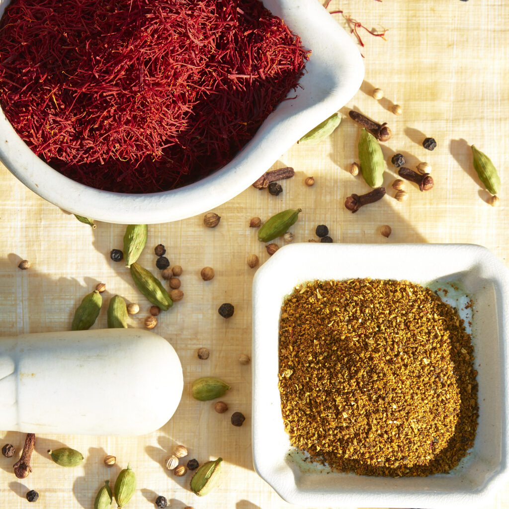 saffron and blended spices in white vessels from above with scattered spices