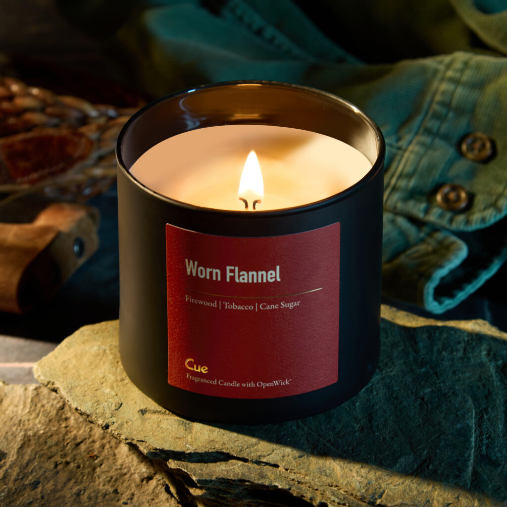Cue Candle Company Worn Flannel candle with rugged propping and green shirt