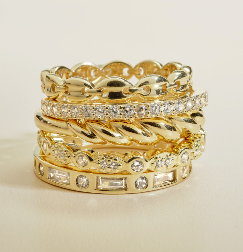 gold and diamond rings in stack on neutral background