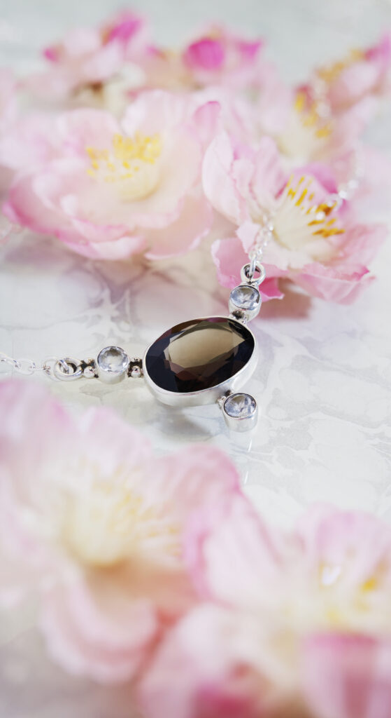 Silver and smokey quartz fair trade pendant on colorful background