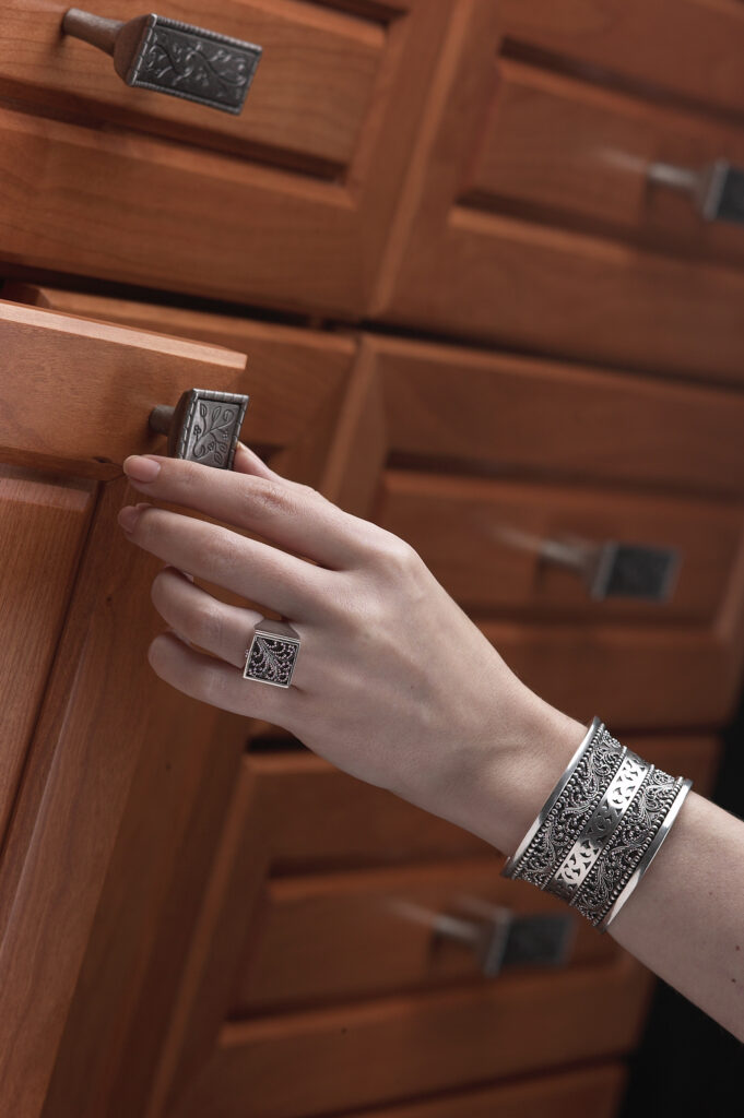 Amerock pewter pulls with hand on mahogany cupboard