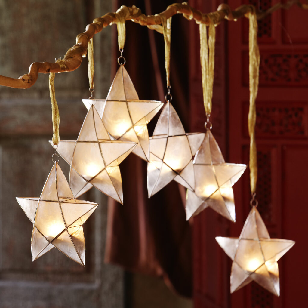fair trade capiz votive holders shaped as stars hanging in a group