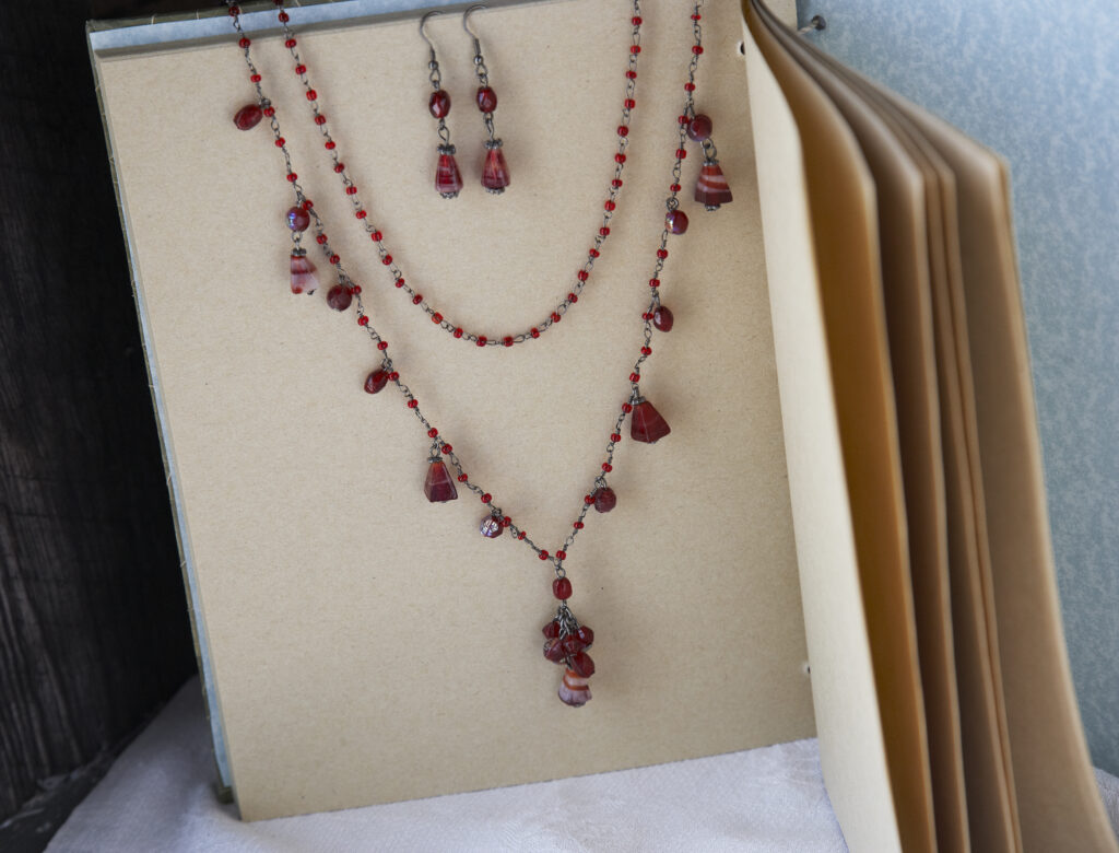 garnet  fair trade necklace and earring set on a romantic background