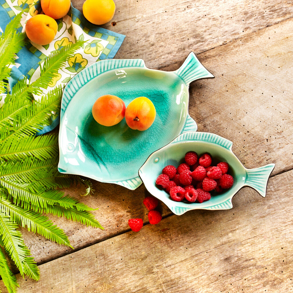 aqua blue fair trade fish plates with fruit on barn wood