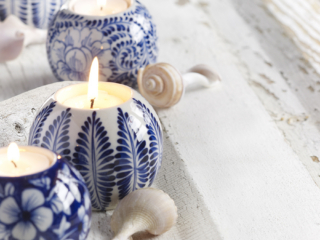 close up of delft style votives with sea shells on white washed wood