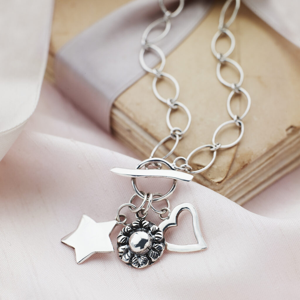 silver charm pendant on a romantic background