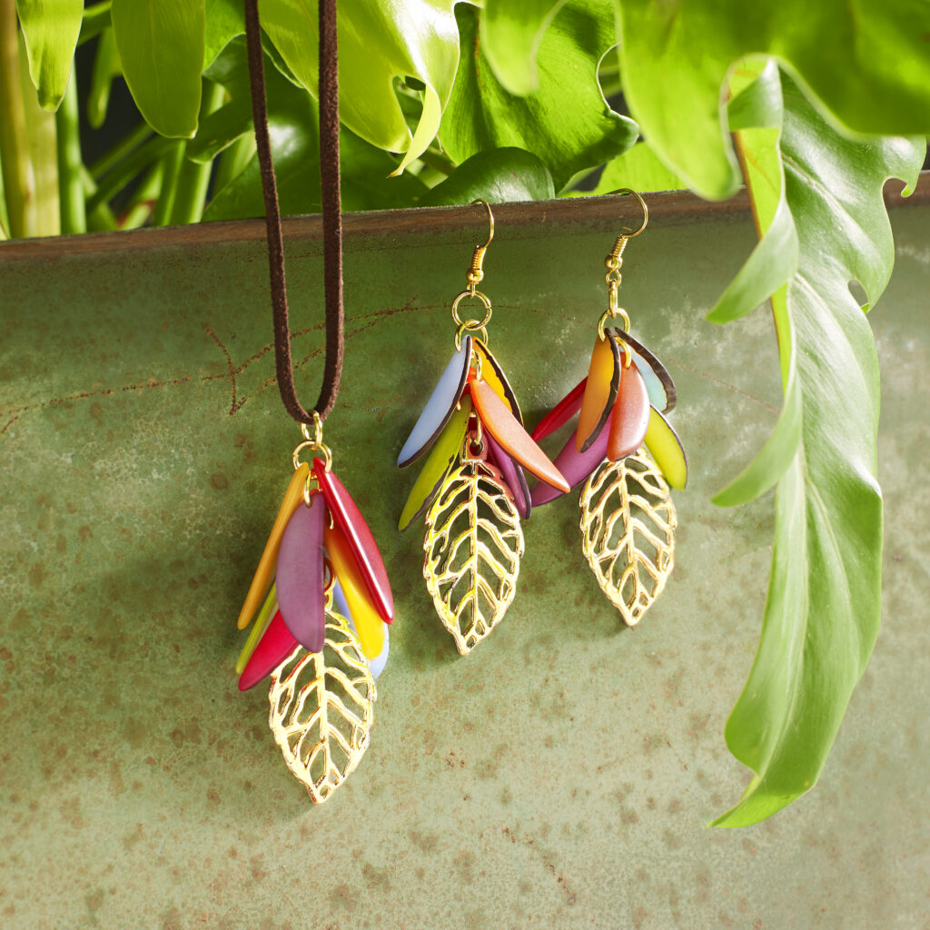 gold and tagua fair trade jewelry set on a lush green background
