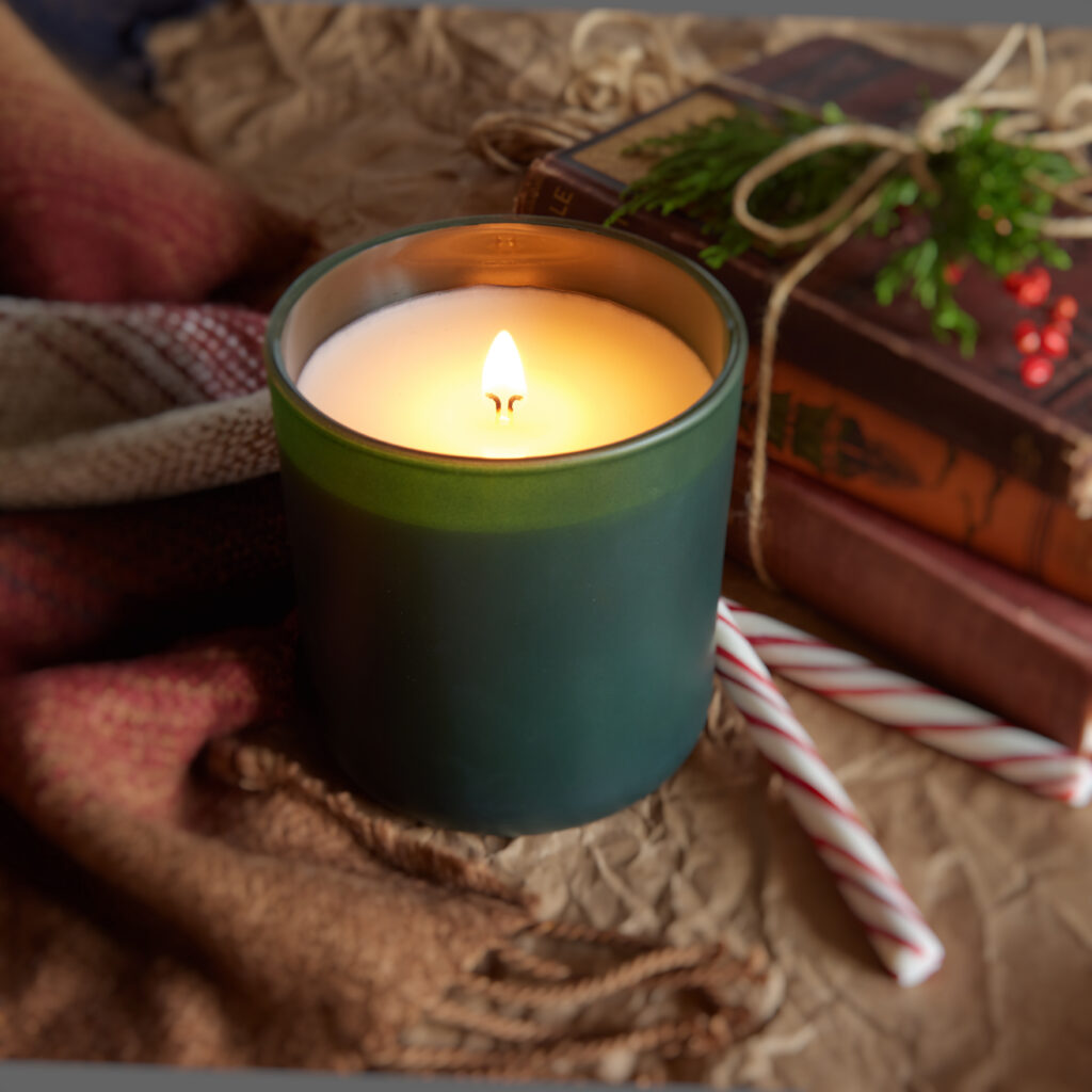 Cue Candle Company frosted green jar with candy canes and books