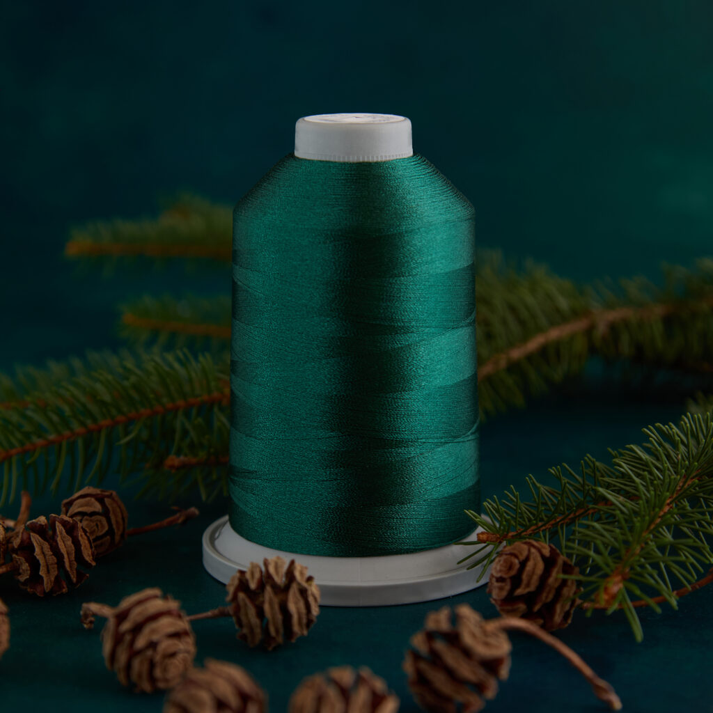 dark green spool of thread with winter greens