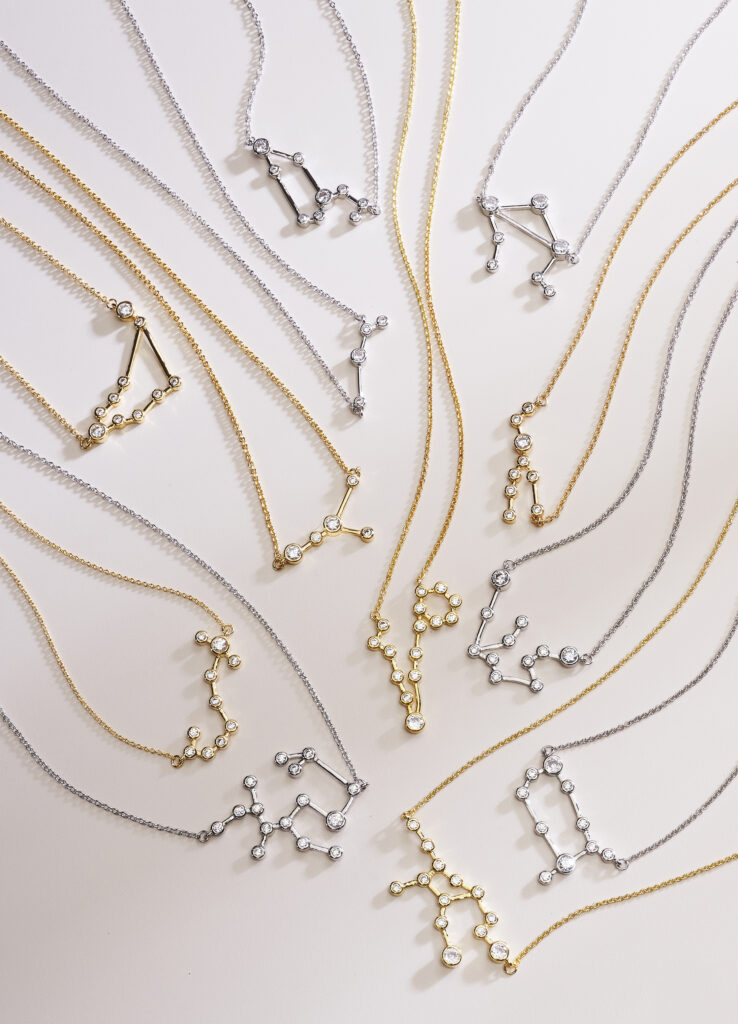 assorted zodiac pendants on neutral colored background with dramatic lighting