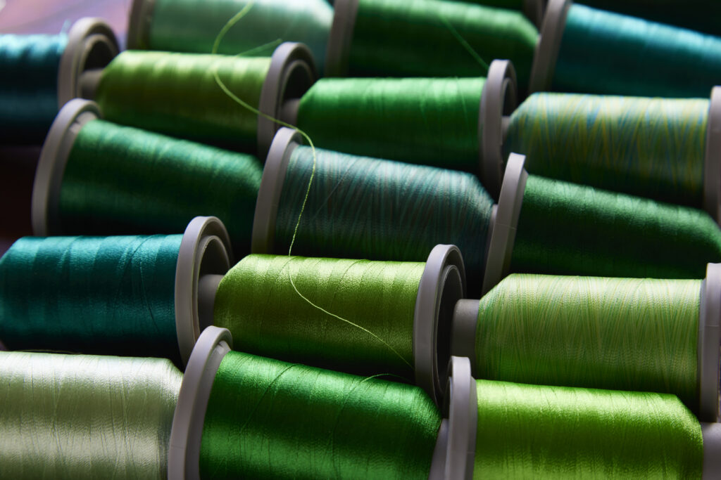 dramatic view of green spools of thread