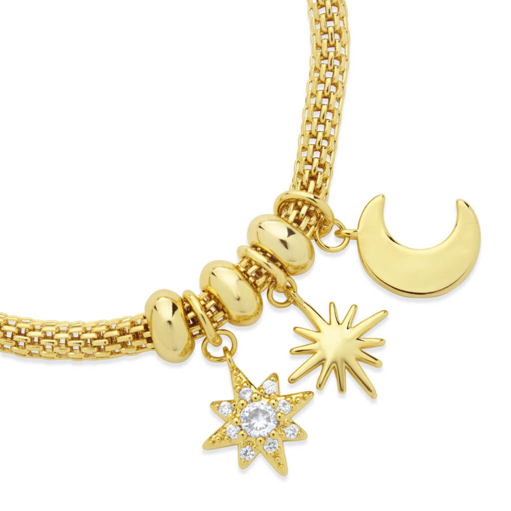 Gold and diamond charms on mesh bracelet on white background