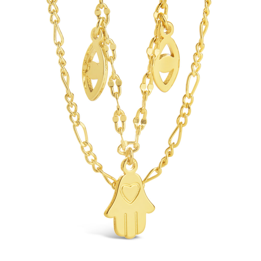 gold layered necklace with eastern peace symbols on white background
