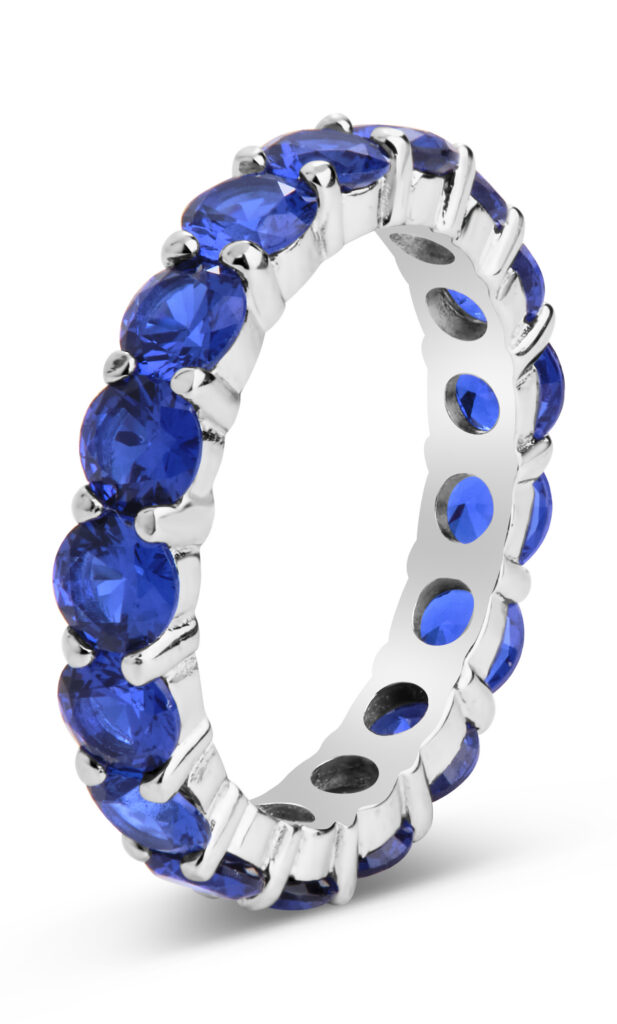 Silver and sapphire ring on white background
