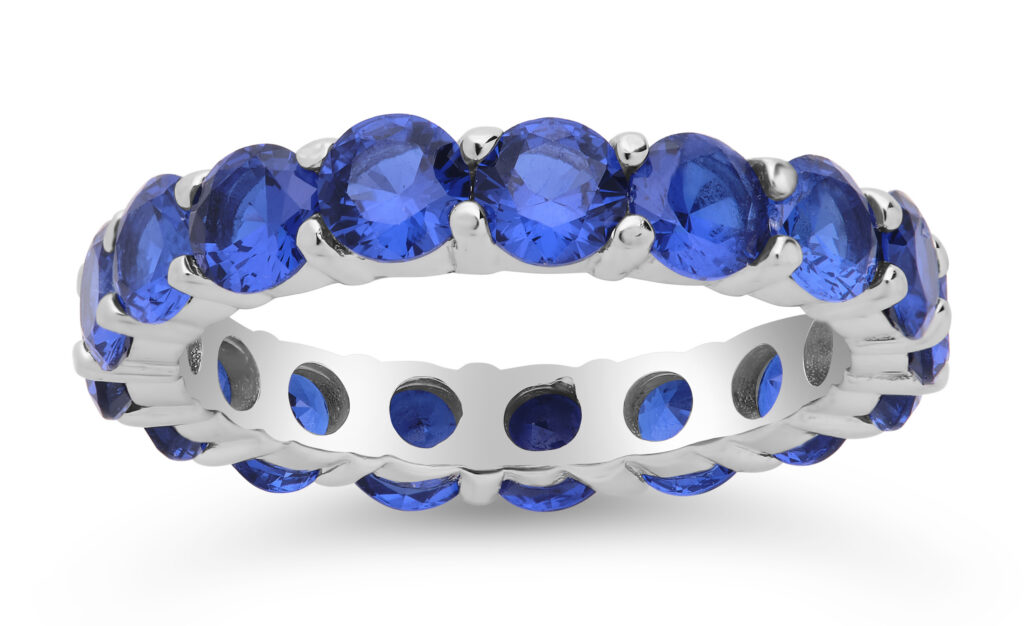 Silver and sapphire ring on white background