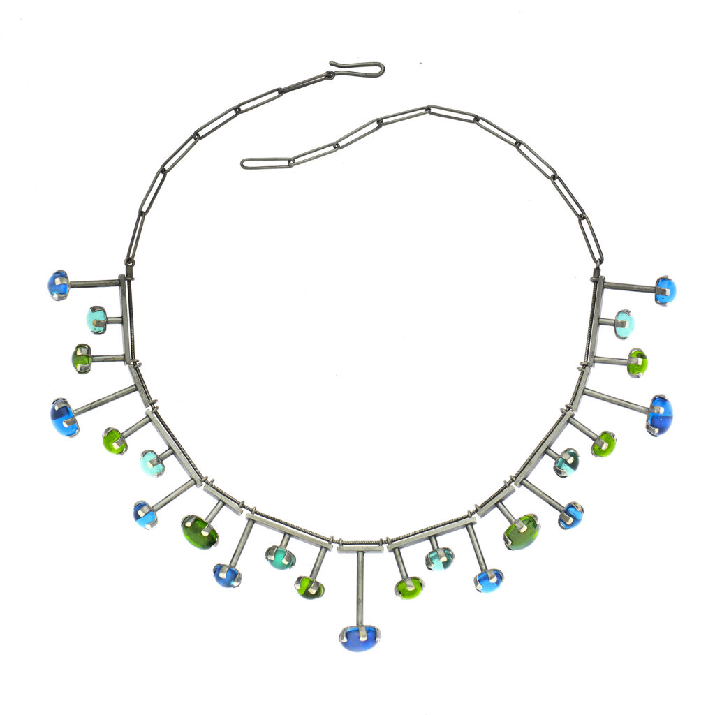 handcrafted necklace with blue and green gems on a white background