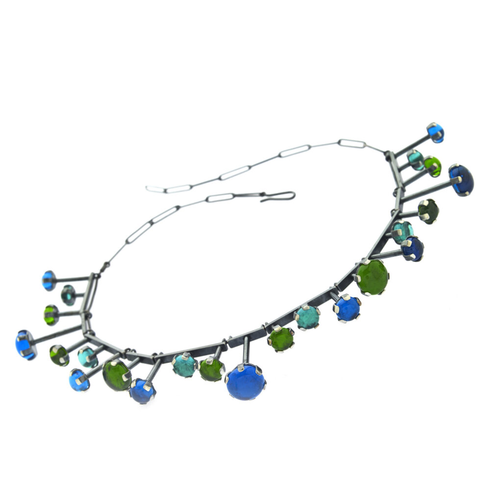 handcrafted necklace with blue and green gems on a white background