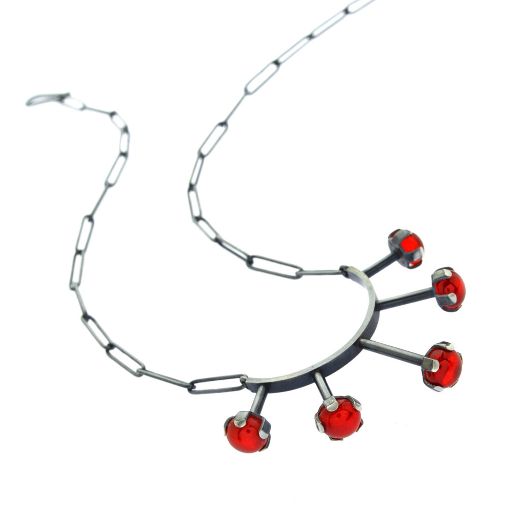 handcrafted necklace with red gems on a white background