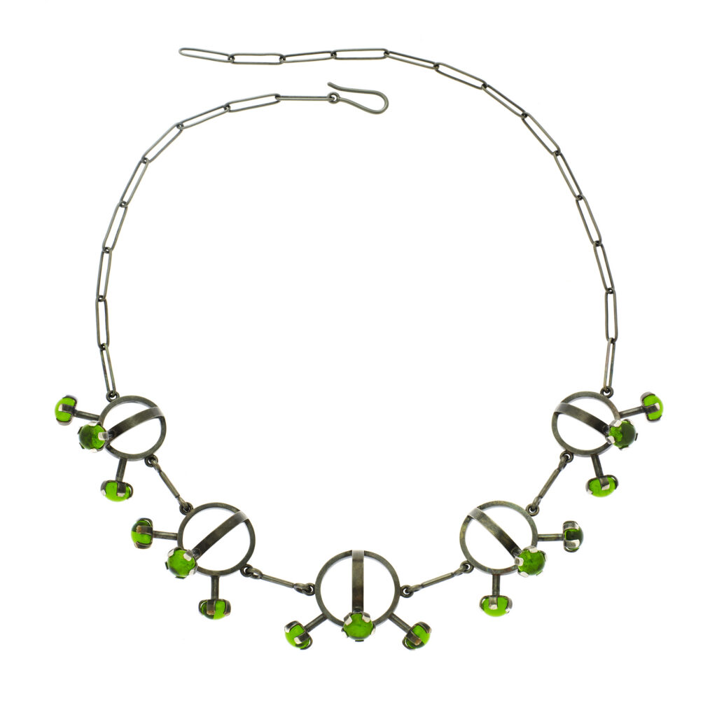 handcrafted necklace with green gems on a white background